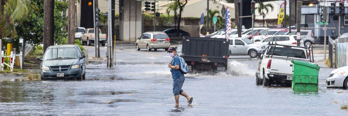 A pedestrian walks across a flooded street in Honolulu, Hawaii on December 7, 2021, the morning after powerful winter tropical storm known as a Kona Low hit the Hawaii islands with heavy rain and high winds causing wide spread flooding and power outages across the state. (Photo: Eugene Tanner/AFP via Getty Images)