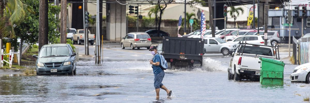 A pedestrian walks across a flooded street in Honolulu, Hawaii on December 7, 2021, the morning after powerful winter tropical storm known as a Kona Low hit the Hawaii islands with heavy rain and high winds causing wide spread flooding and power outages across the state. (Photo: Eugene Tanner/AFP via Getty Images)
