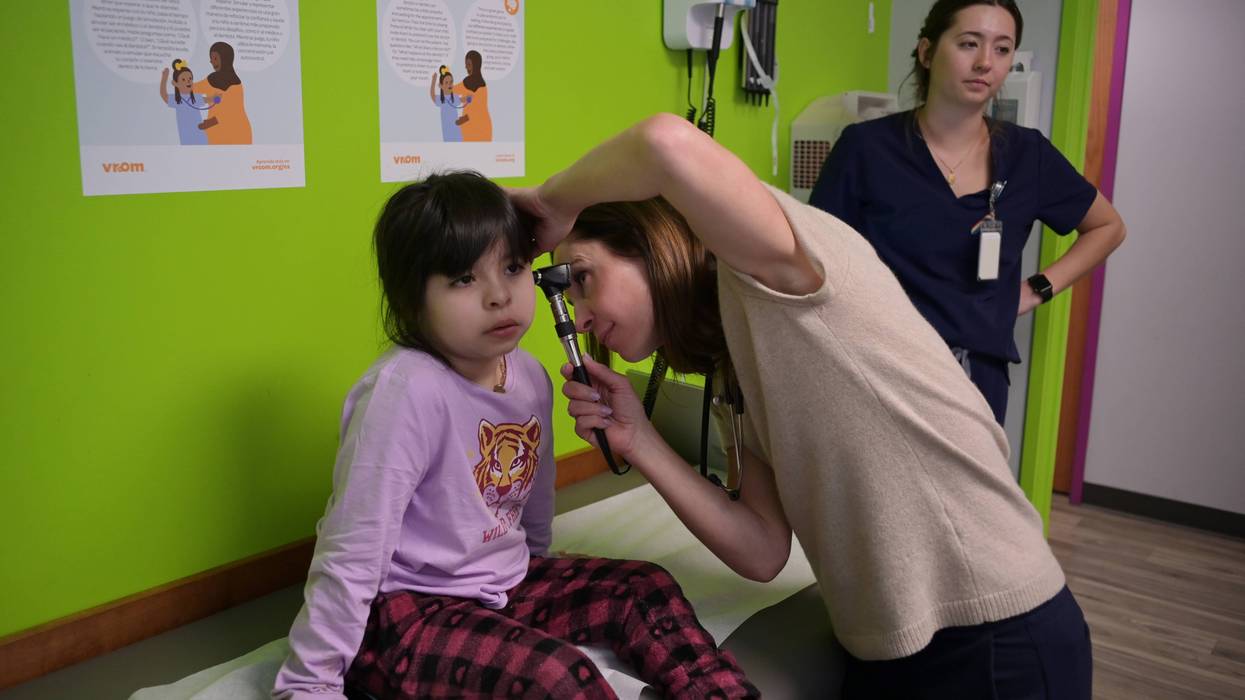 A pediatrician examines a child