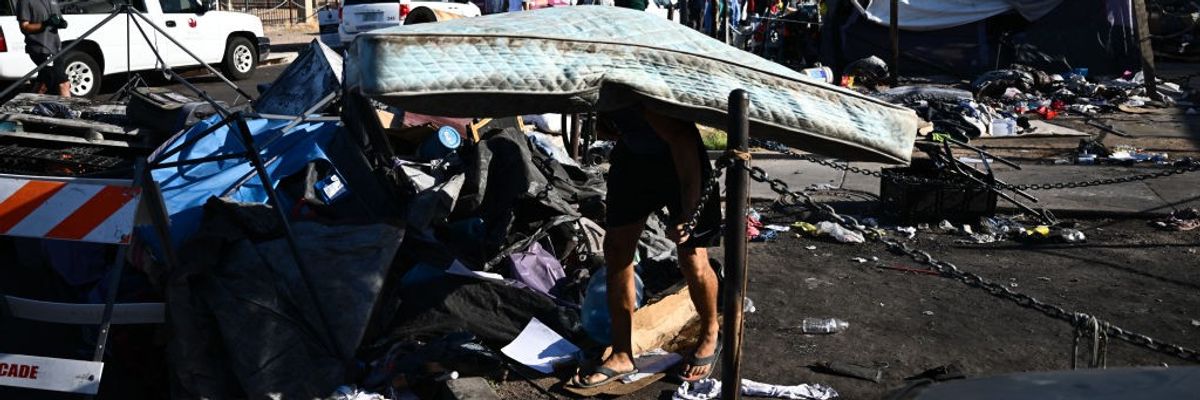 A person carries a mattress on their back during a heatwave.