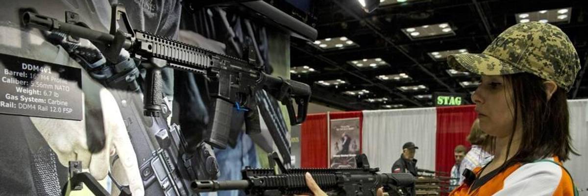 A person examines a gun at an NRA meeting