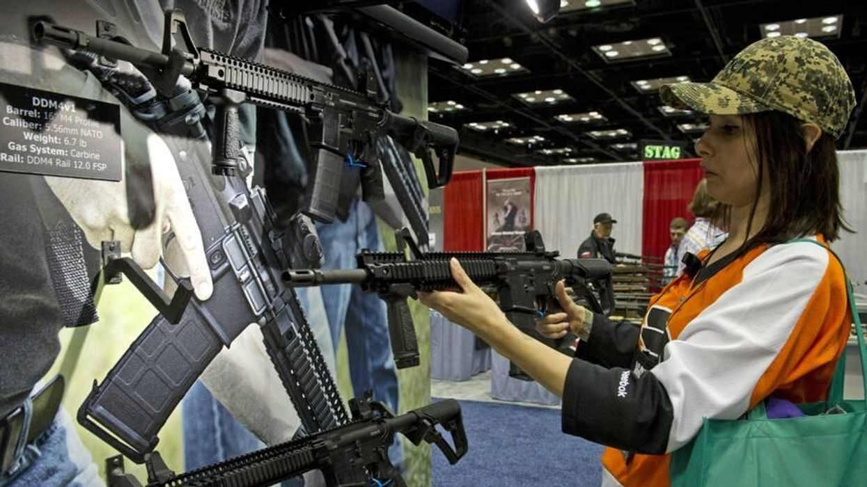 A person examines a gun at an NRA meeting