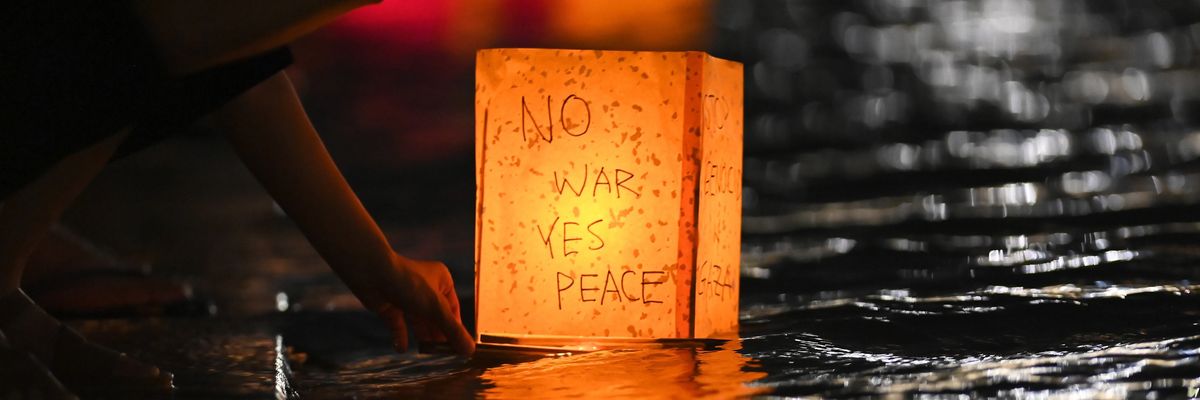 A person floats a lantern in Hiroshima reading, "No war, yes peace."