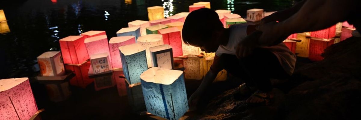A person floats a lantern on the water on the 78th anniversary of the bombing of Hiroshima.