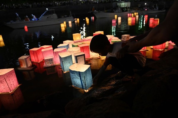 A person floats a lantern on the water on the 78th anniversary of the bombing of Hiroshima.