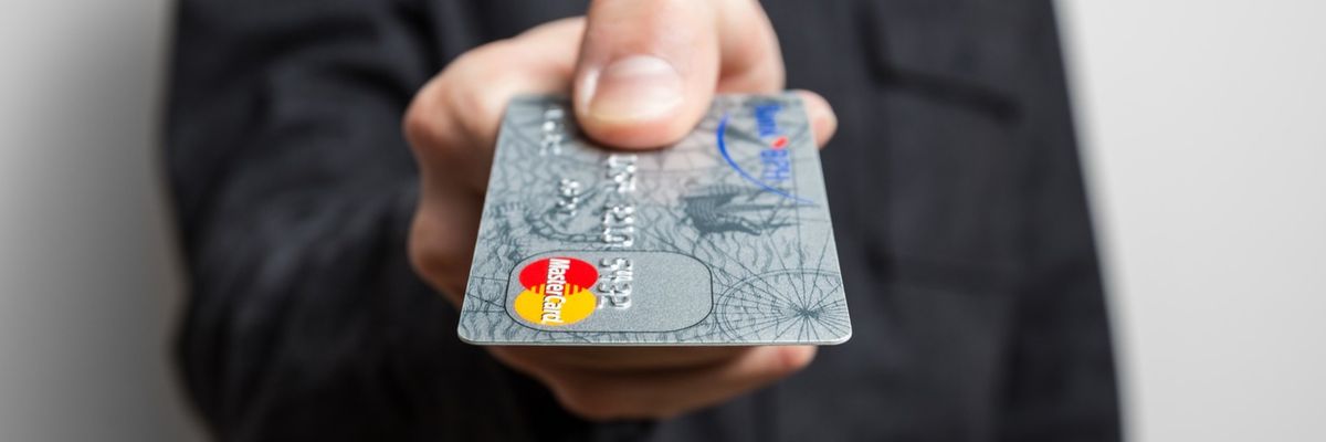 A person hands over a credit card