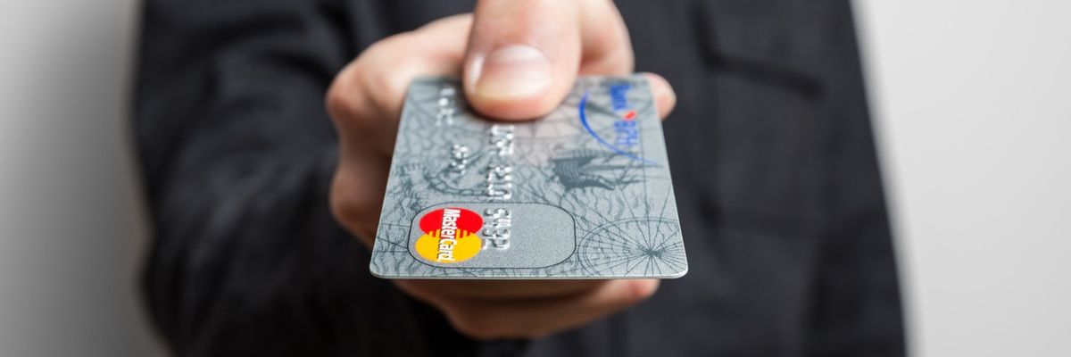 A person hands over a credit card 