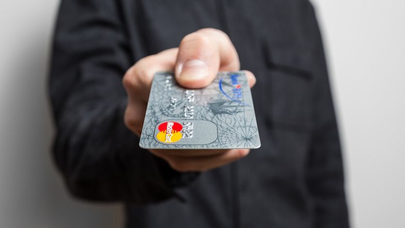 A person hands over a credit card