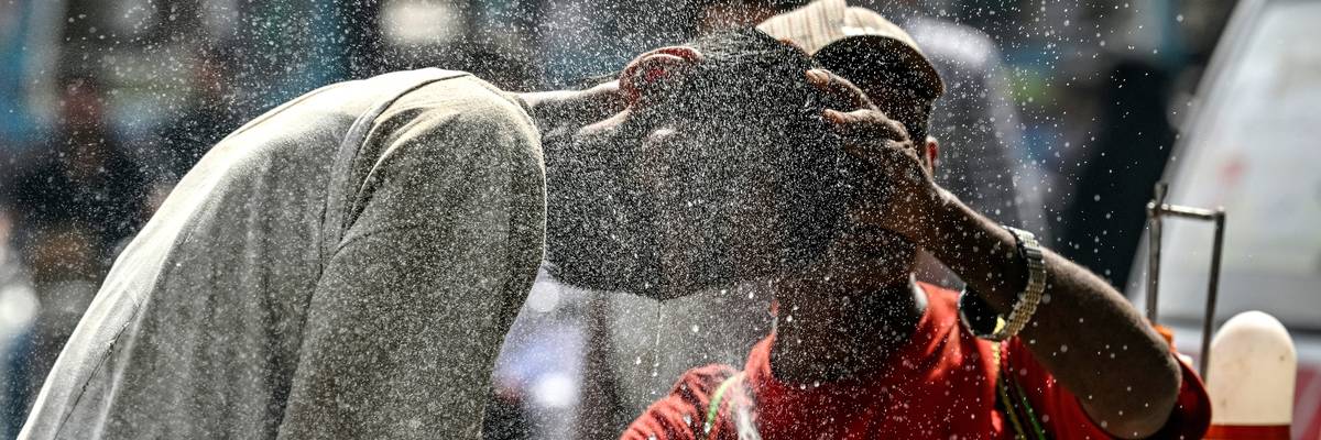 A person helps another cool off in a heatwave in Pakistan.