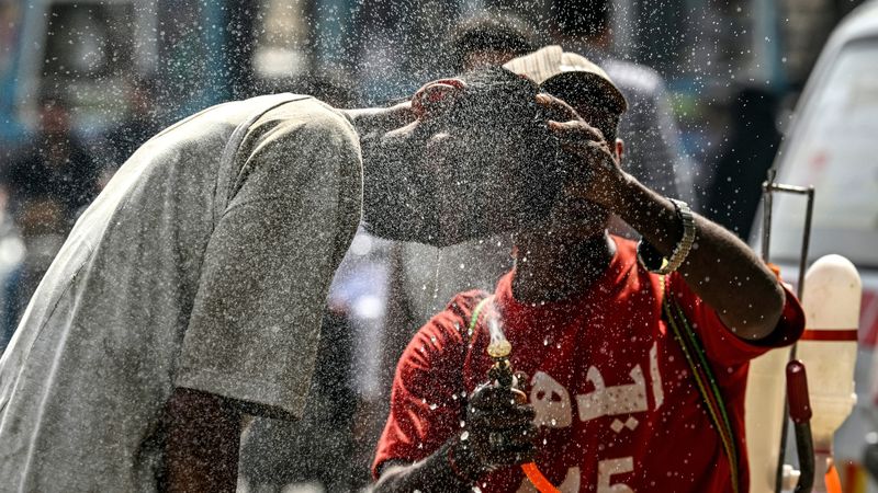 A person helps another cool off in a heatwave in Pakistan.