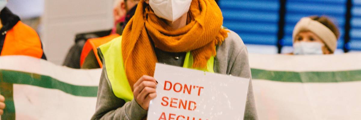 A person holds a placard during a rally against deportations to Afghanistan on January 12, 2021 in an airport in Duesseldorf, Germany. (Photo: Ying Tang/NurPhoto via Getty Images)