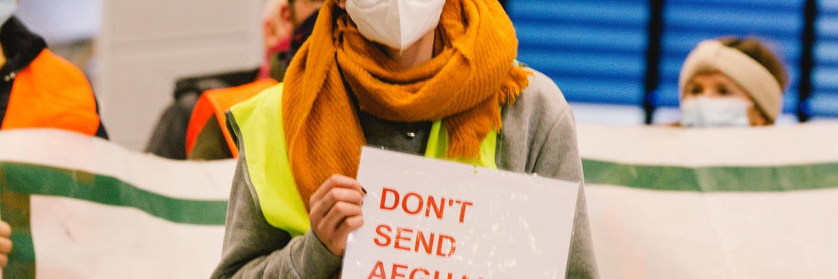 A person holds a placard during a rally against deportations to Afghanistan on January 12, 2021 in an airport in Duesseldorf, Germany. (Photo: Ying Tang/NurPhoto via Getty Images)
