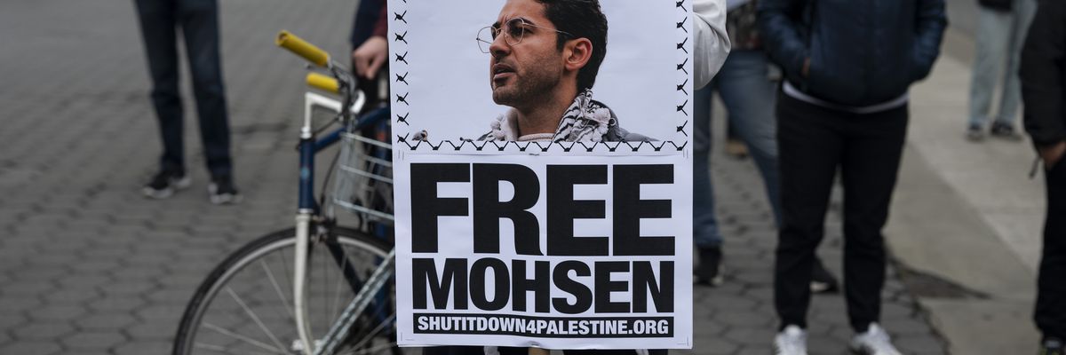 A person holds a poster saying, "Free Moshen."