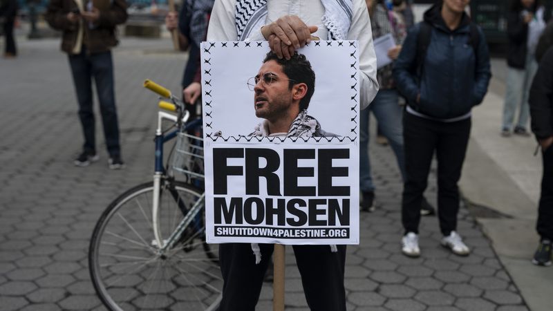 A person holds a poster saying, "Free Moshen."