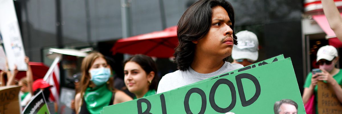 A person holds a sign condemning Supreme Court Justices Clarence Thomas, Samuel Alito, Amy Coney Barrett, Neil Gorsuch, and Brett Kavanaugh during a demonstration outside a Planned Parenthood clinic on July 16, 2022 in Santa Monica, California.