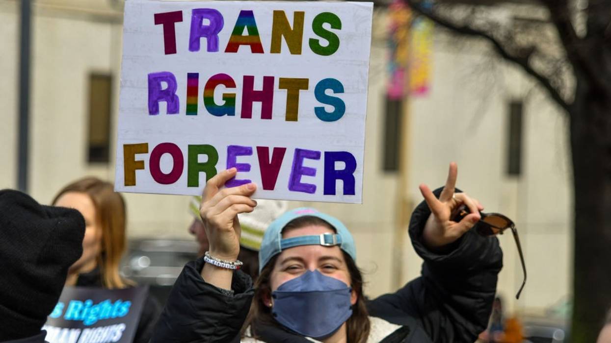 A person holds a sign reading, "Trans rights forever."
