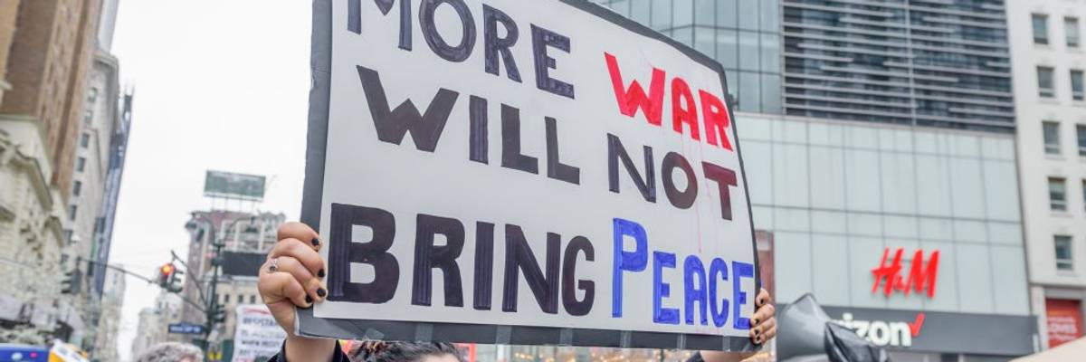 A person holds a sign saying, "More war will not bring peace" in New York City.