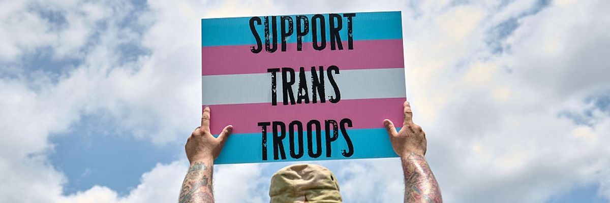 A person holds a sign supporting transgender veterans