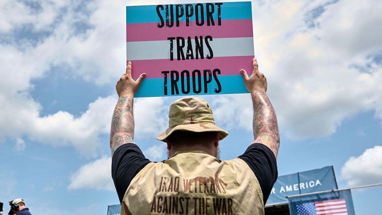 A person holds a sign supporting transgender veterans