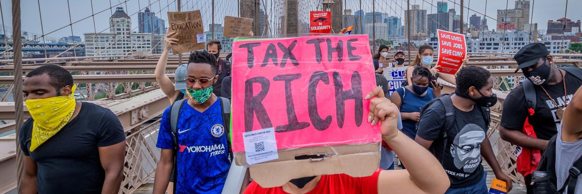 A person holds a Tax The Rich sign at a June 27, 2020 protest march in New York City. (Photo: Erik McGregor/LightRocket via Getty Images)