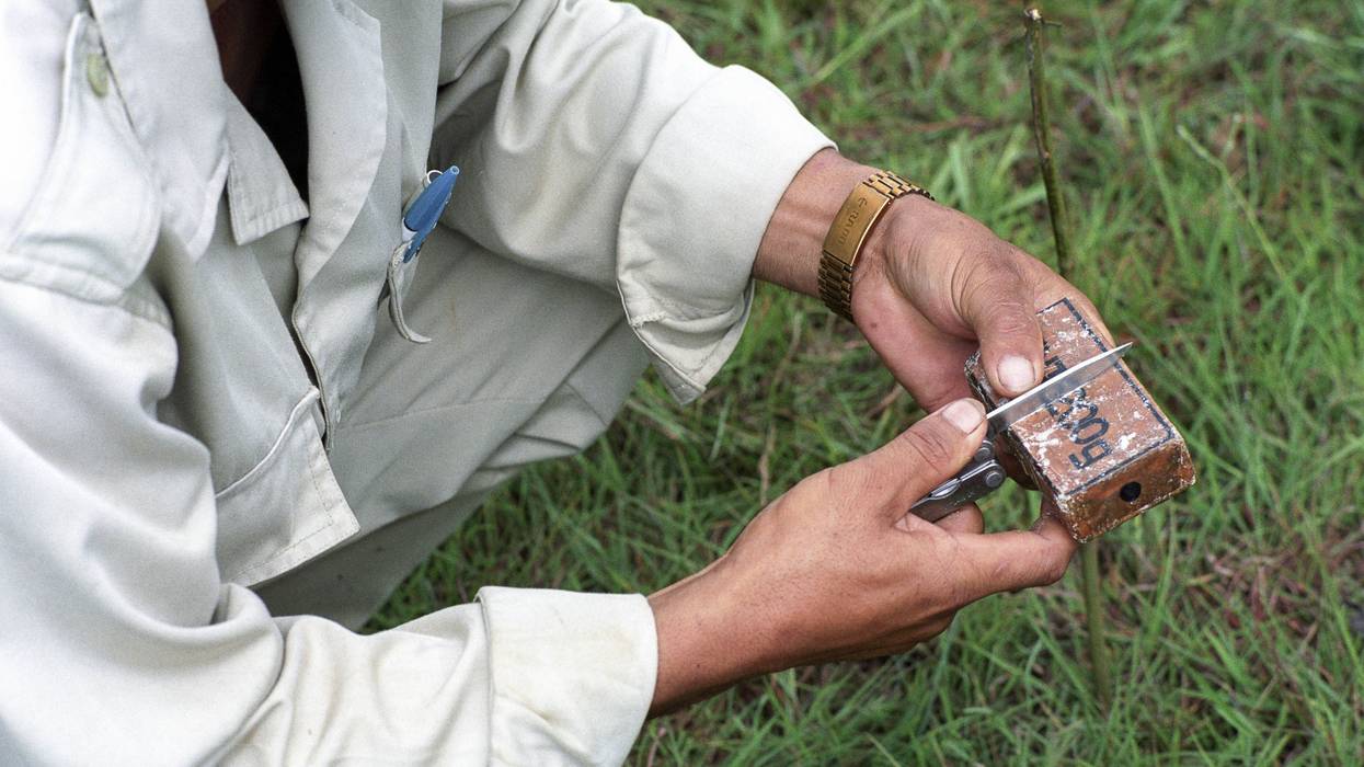 A person holds unexploded ordnance.