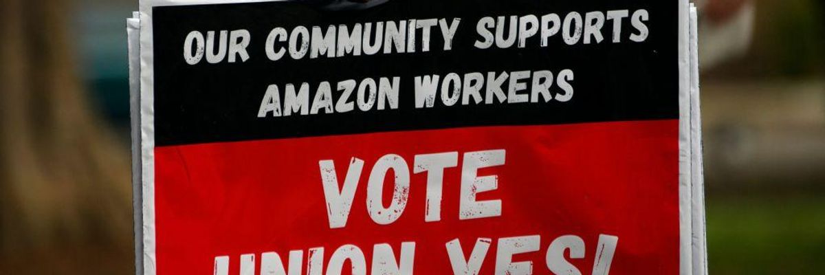 A person holds "Vote Union Yes!" signs during a protest in solidarity with Black Lives Matter, Stop Asian Hate and the unionization of Amazon.com, Inc. fulfillment center workers at Kelly Ingram Park on March 27, 2021 in Birmingham, Alabama.