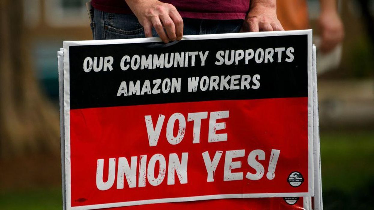 A person holds "Vote Union Yes!" signs during a protest in solidarity with Black Lives Matter, Stop Asian Hate and the unionization of Amazon.com, Inc. fulfillment center workers at Kelly Ingram Park on March 27, 2021 in Birmingham, Alabama.