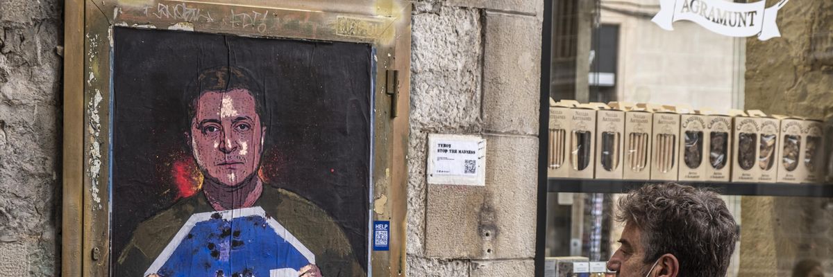 A person in Barcelona, Spain is seen observing the graphic representation of Ukrainian President Volodymyr Zelenskyy calling for an end to Russia's invasion on March 7, 2022. 