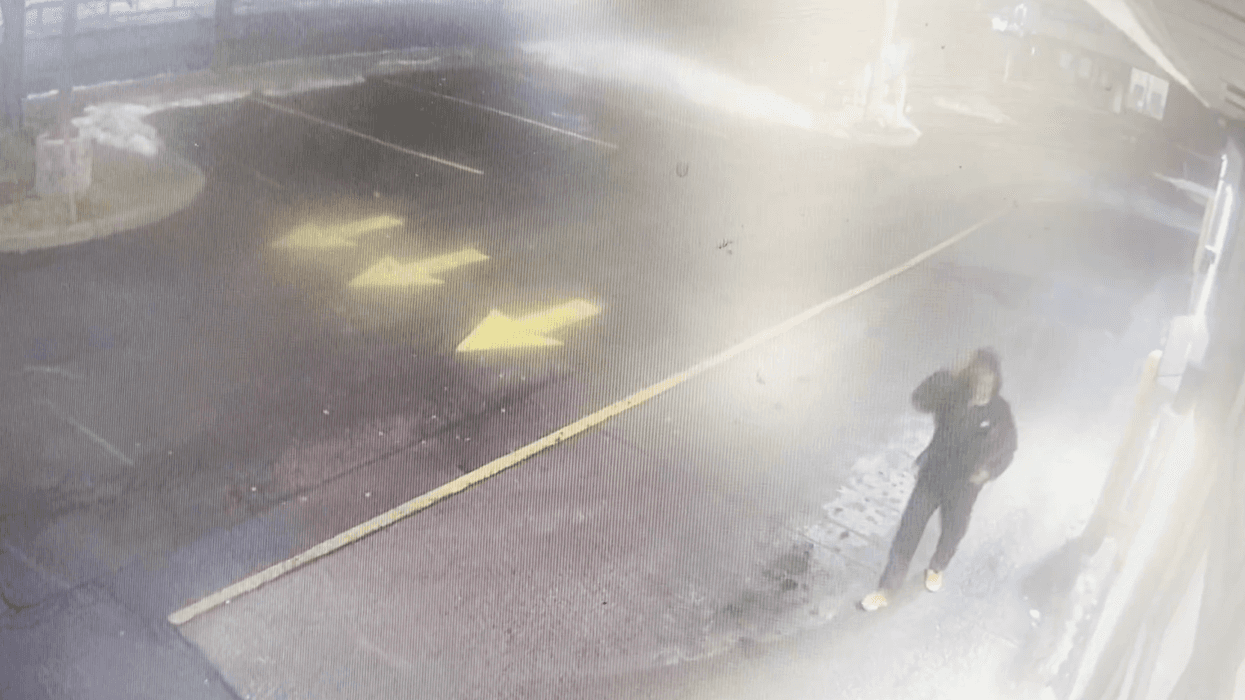 A person matching the description of Nurul Shah Alam walks through the parking lot at a Tim Hortons donut shop