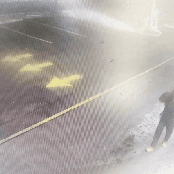 A person matching the description of Nurul Shah Alam walks through the parking lot at a Tim Hortons donut shop