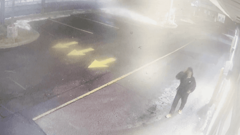 A person matching the description of Nurul Shah Alam walks through the parking lot at a Tim Hortons donut shop