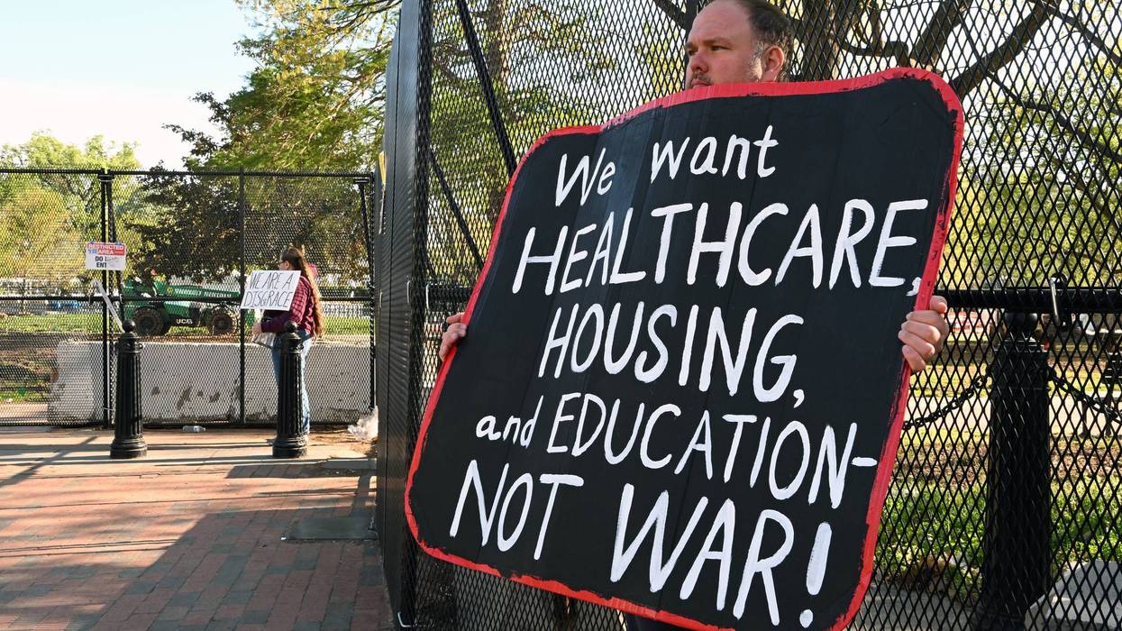 A person protests the Iran War outside the White House.