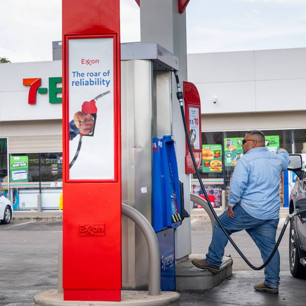 A person pumps gas at an Exxon station