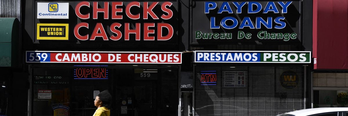 A person rides a scooter past a check cashing and payday loans store on March 11, 2022 in downtown Los Angeles, California.
