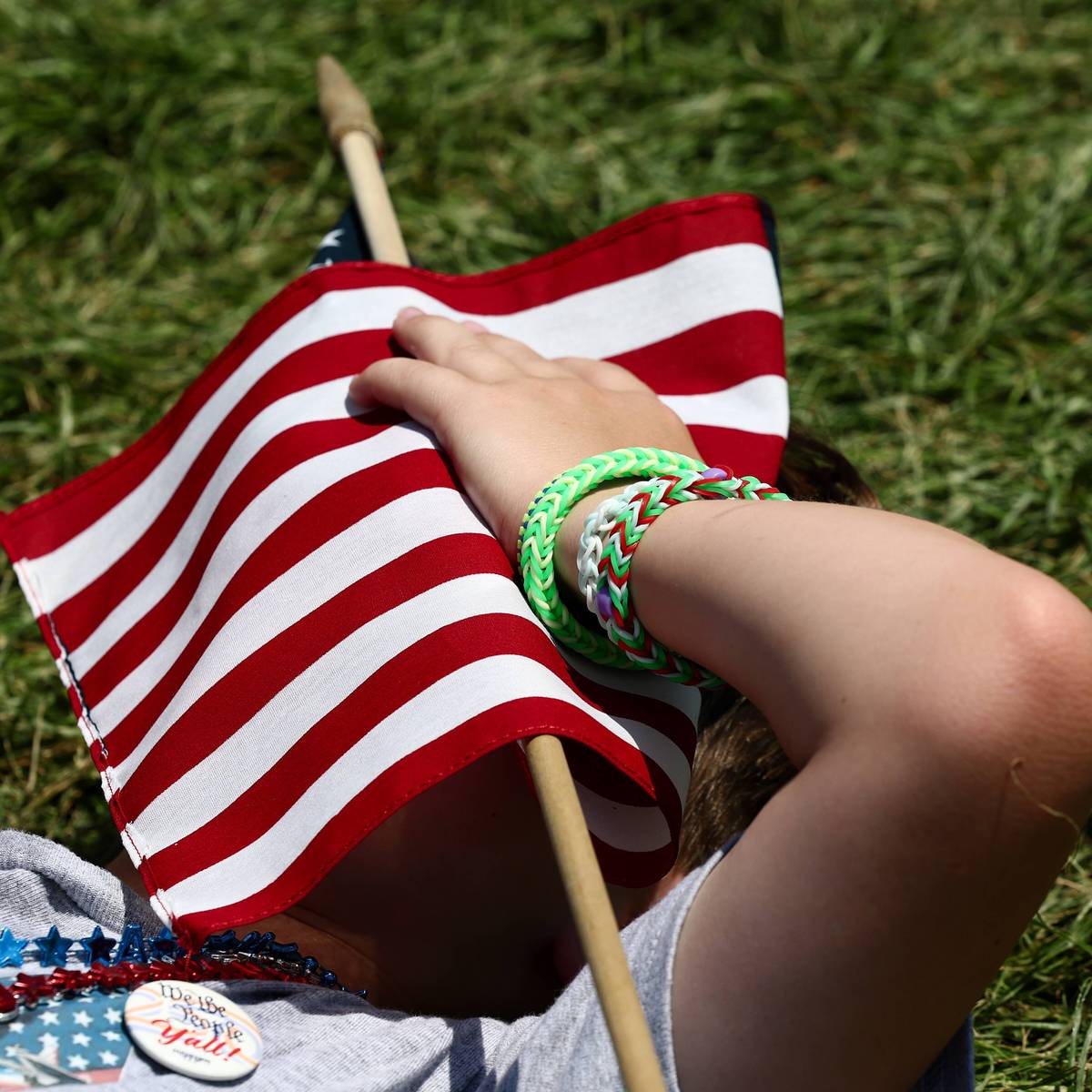 A person shelters from the heat with a US flag.