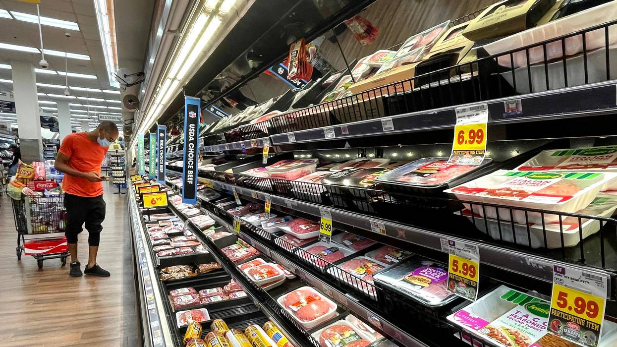 A person shops for meat at a grocery store