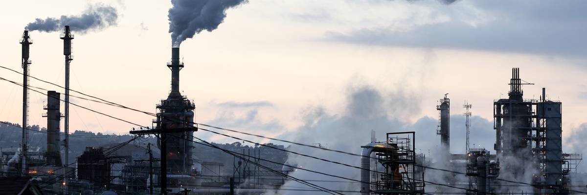 A Phillips 66 refinery stands beyond a residential street