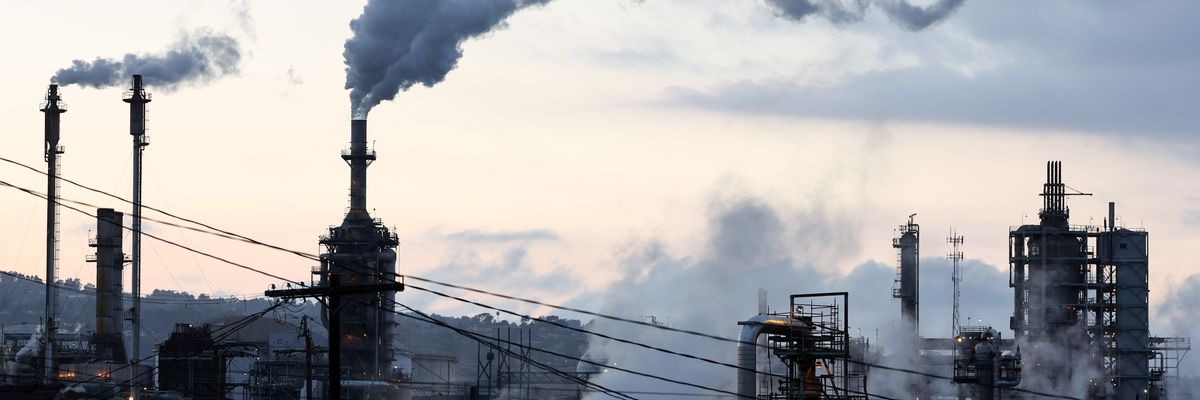 A Phillips 66 refinery stands beyond a residential street
