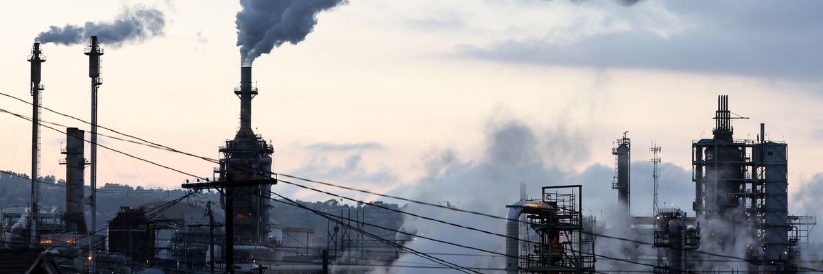 A Phillips 66 refinery stands beyond a residential street