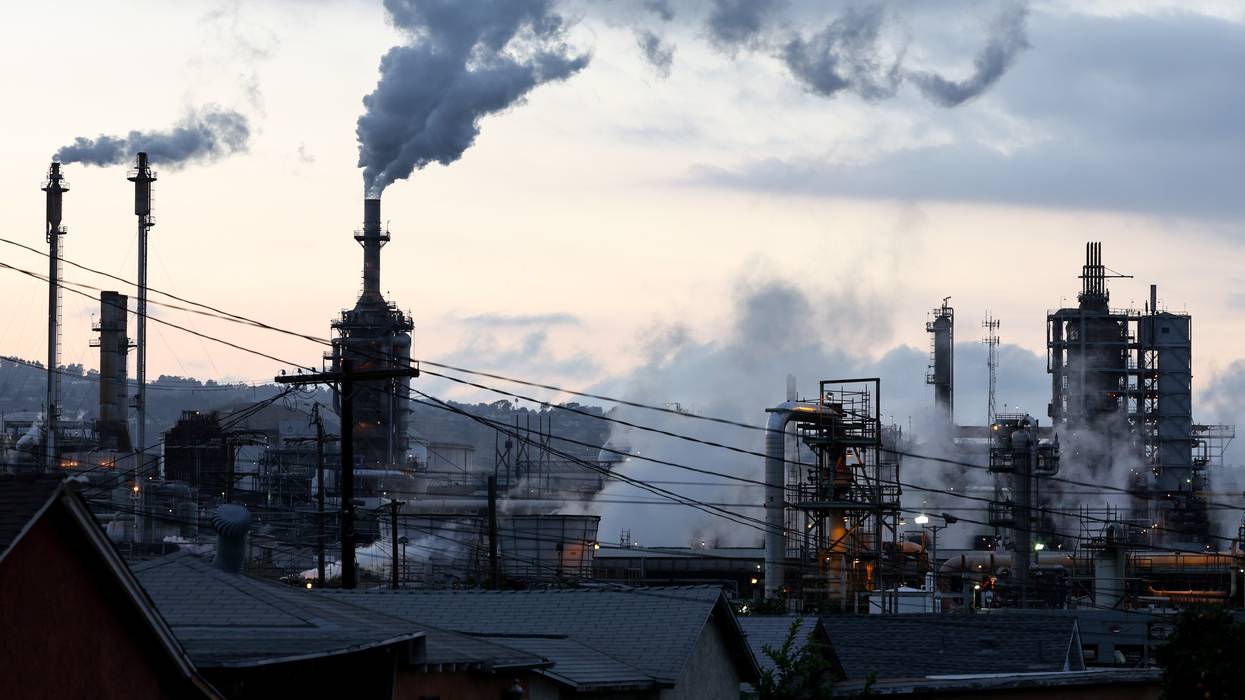 A Phillips 66 refinery stands beyond a residential street