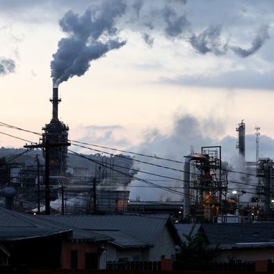 A Phillips 66 refinery stands beyond a residential street