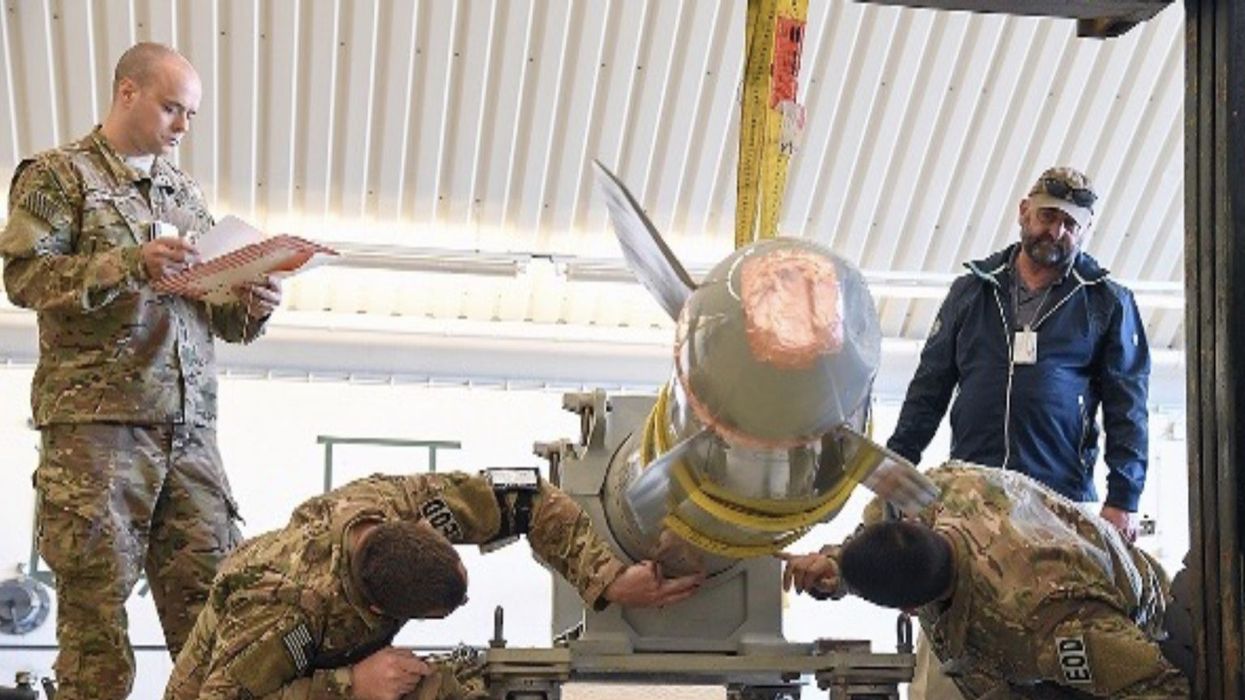 A photo in a Los Alamos National Laboratory student briefing from April 2022 shows four people inspecting what appears to be a damaged B61 nuclear bomb.