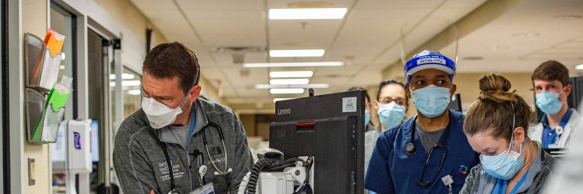 A physician looks into a Covid-19 patient's room