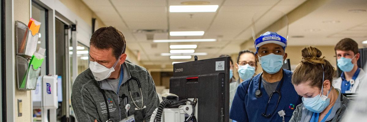 A physician looks into a Covid-19 patient's room