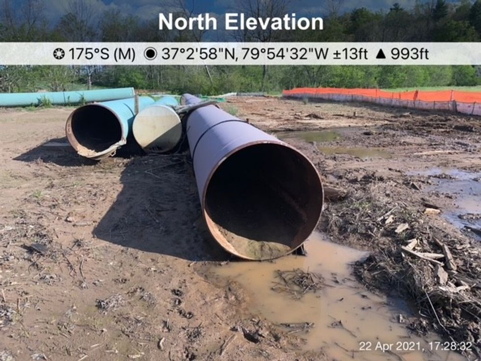 A piece of pipeline sitting in muddy water.