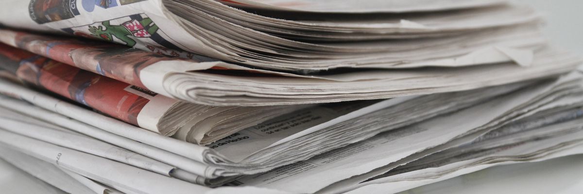 A pile of newspapers on table