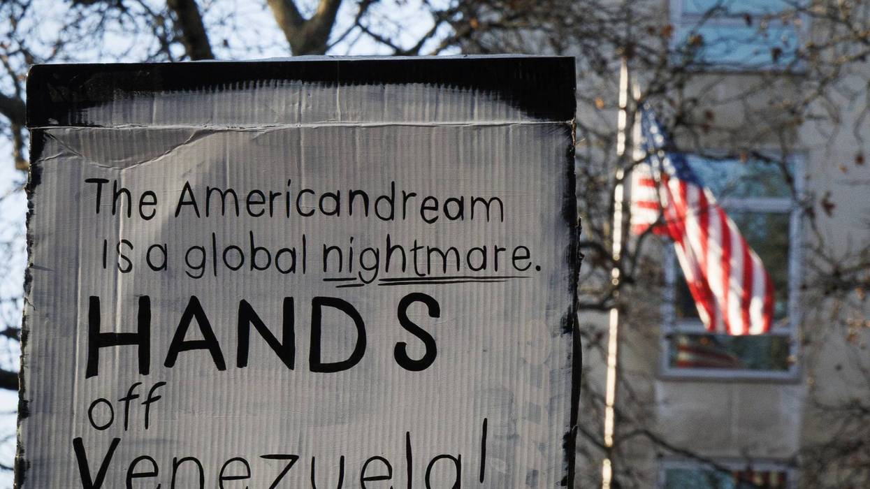 A placard reads, "American dream is a global nightmare, hands off Venezuela."