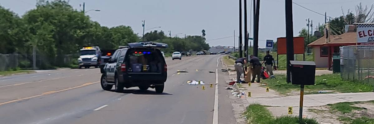 A police vehicle in front of a crash site on an empty road.