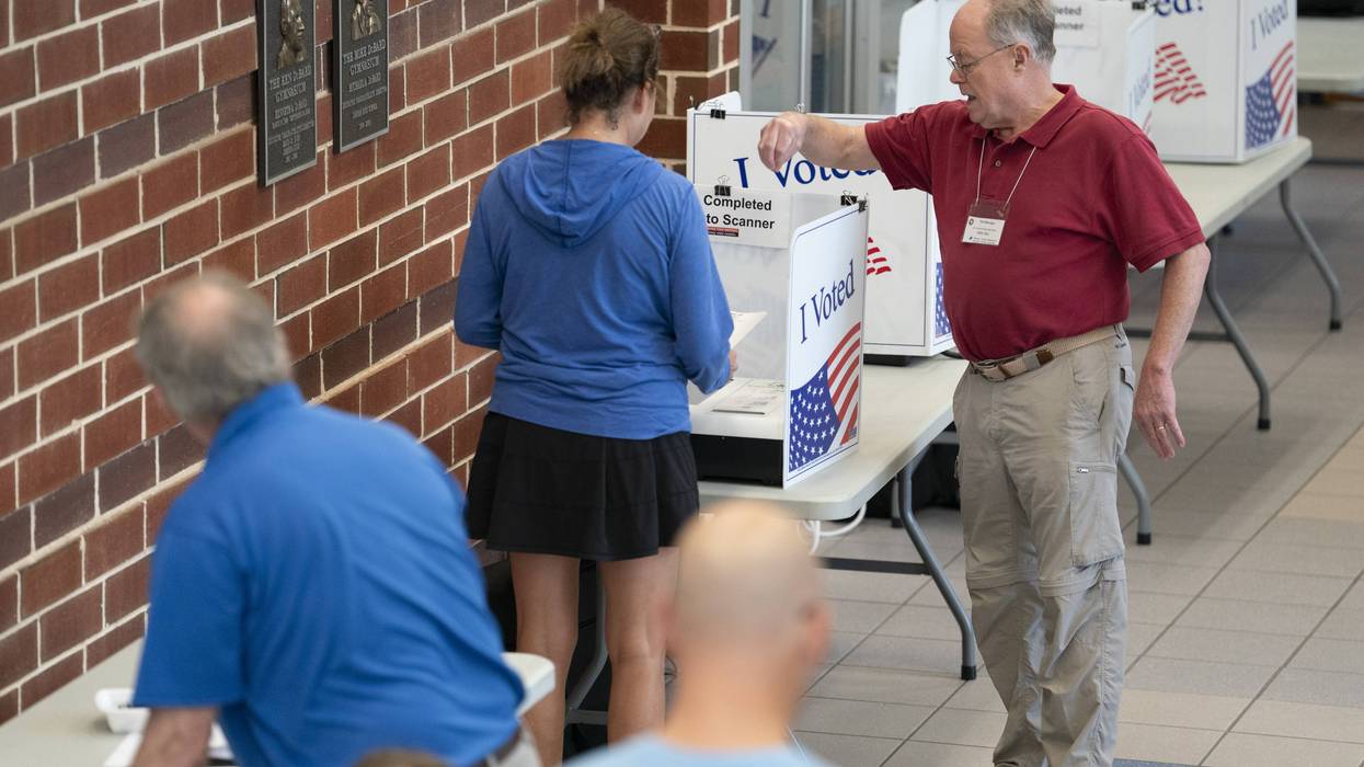 A poll worker helps a woman cast a midterm primary vote on Election Day