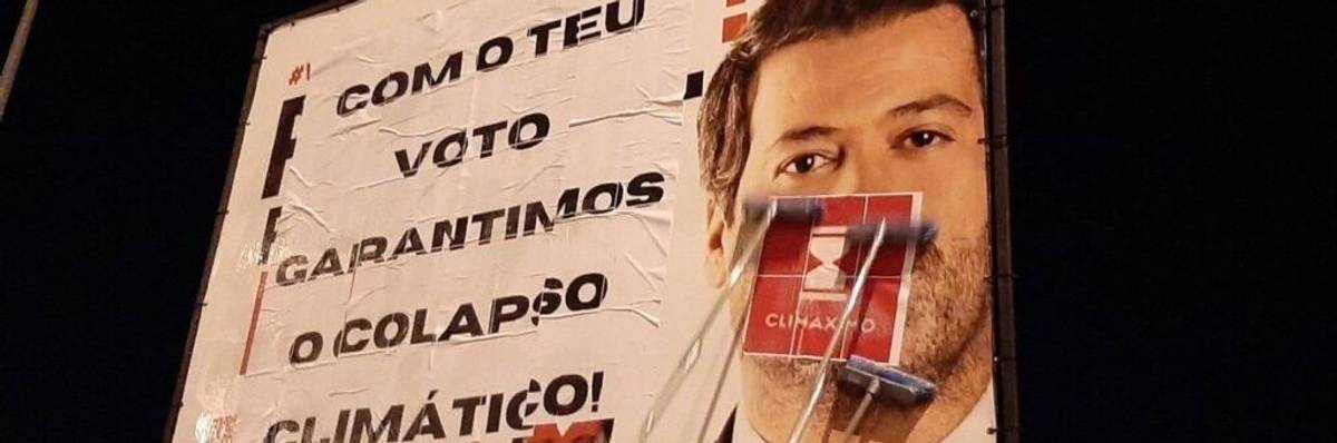 A Portuguese election billboard is modified to read, "With your vote we guarantee climate collapse."
